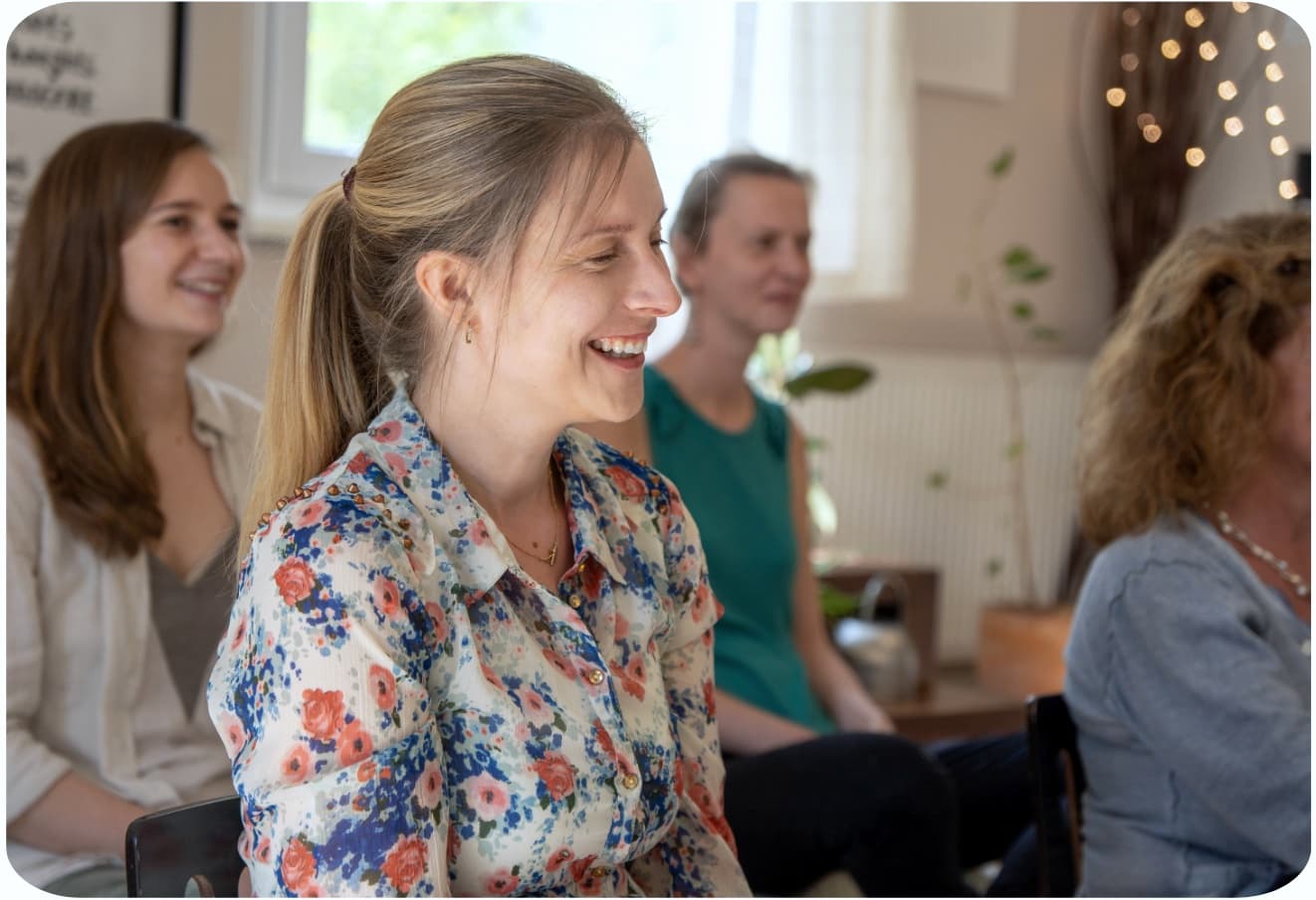 Lächelnde Teilnehmerin während einer Meditationssitzung im Berliner Zentrum