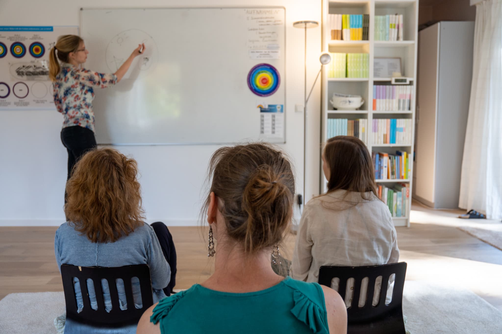 Meditationslehrerin erklärt die Methode vor einer kleinen Gruppe
